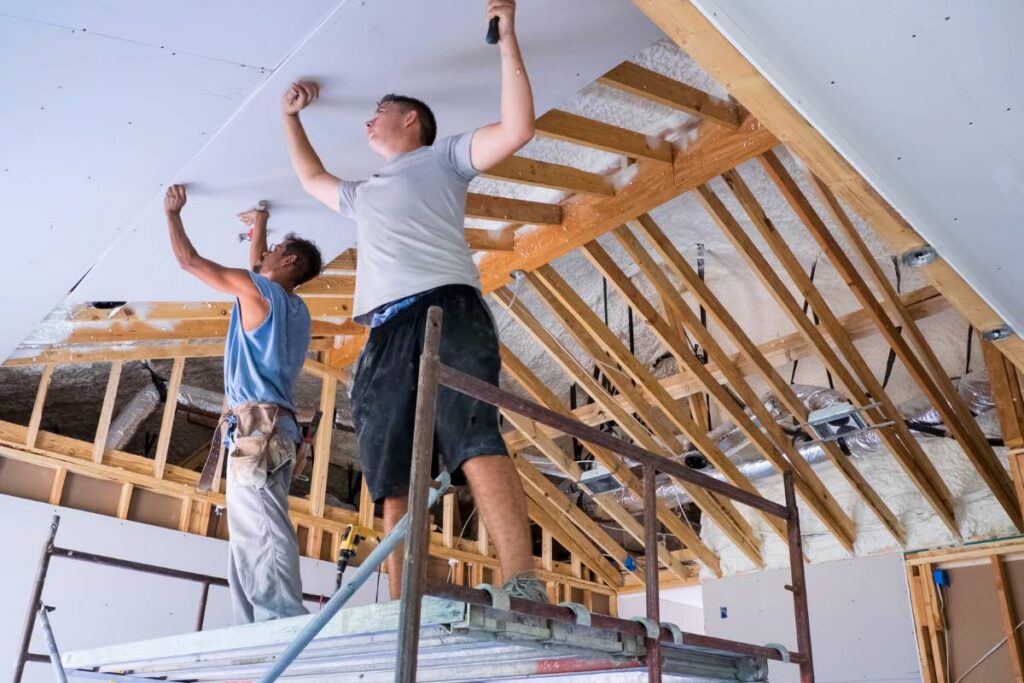 An assortment of drywall panels, including regular, greenboard, and fire-resistant varieties, stacked neatly