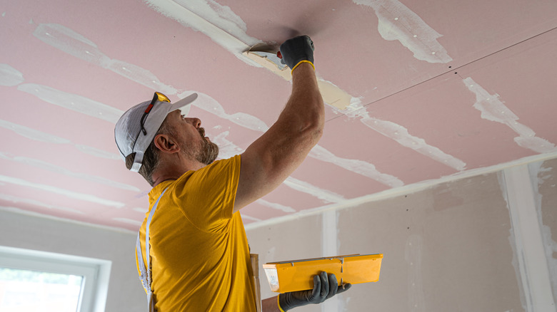 Water stain on drywall ceiling being inspected for active leak source